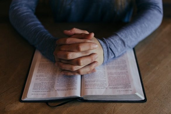Мужчина положил руки на книгу